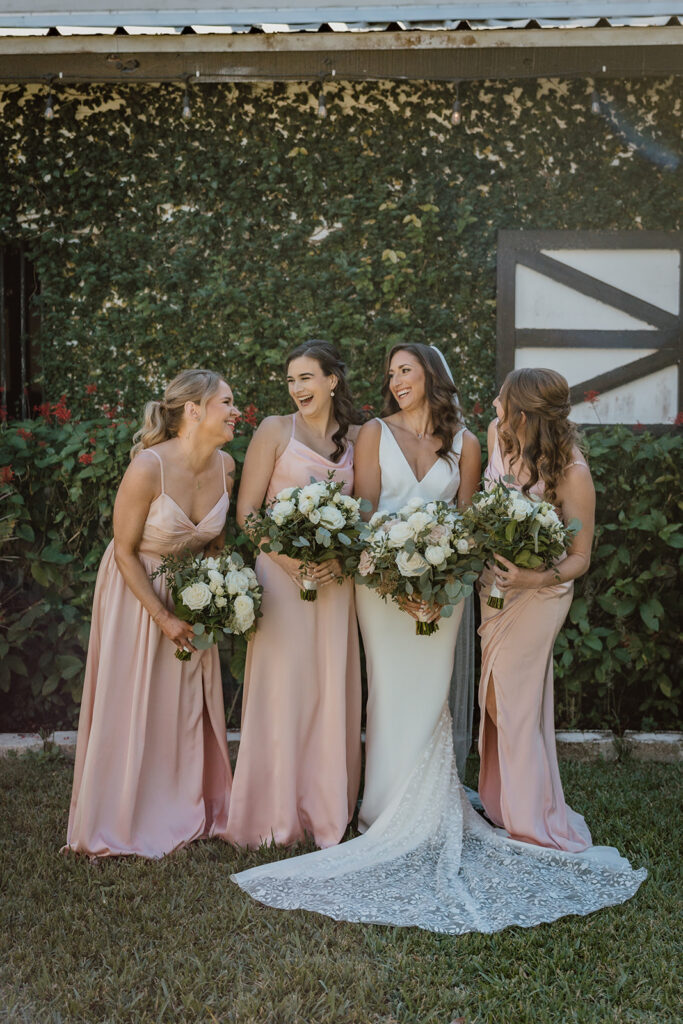 bridesmaids and brides laughing at each other outside