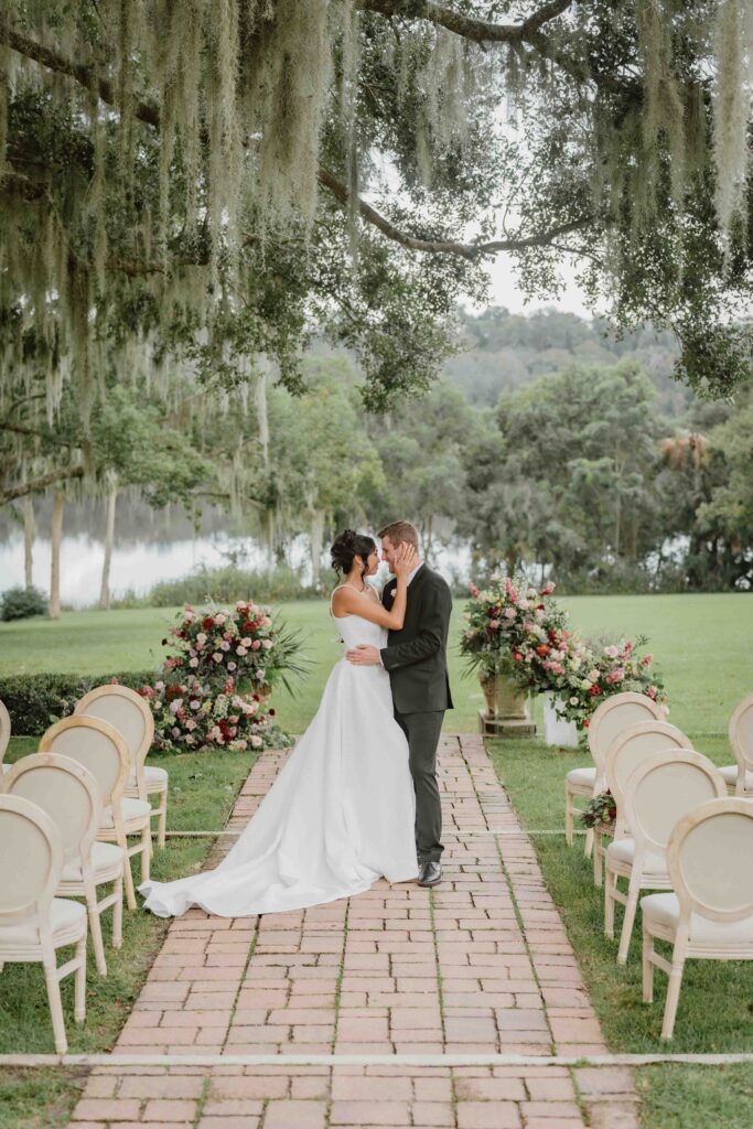 bride and groom looking at each other at a wedding ceremony outdoors under a tree.