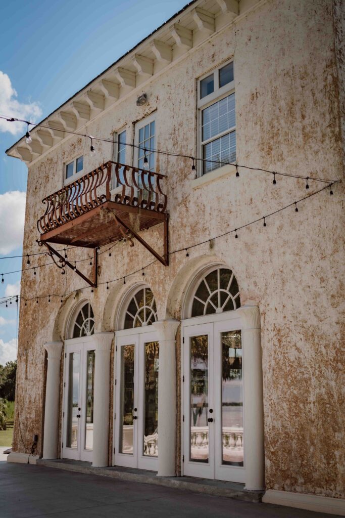 back side of wedding venue with three doors and a balcony
