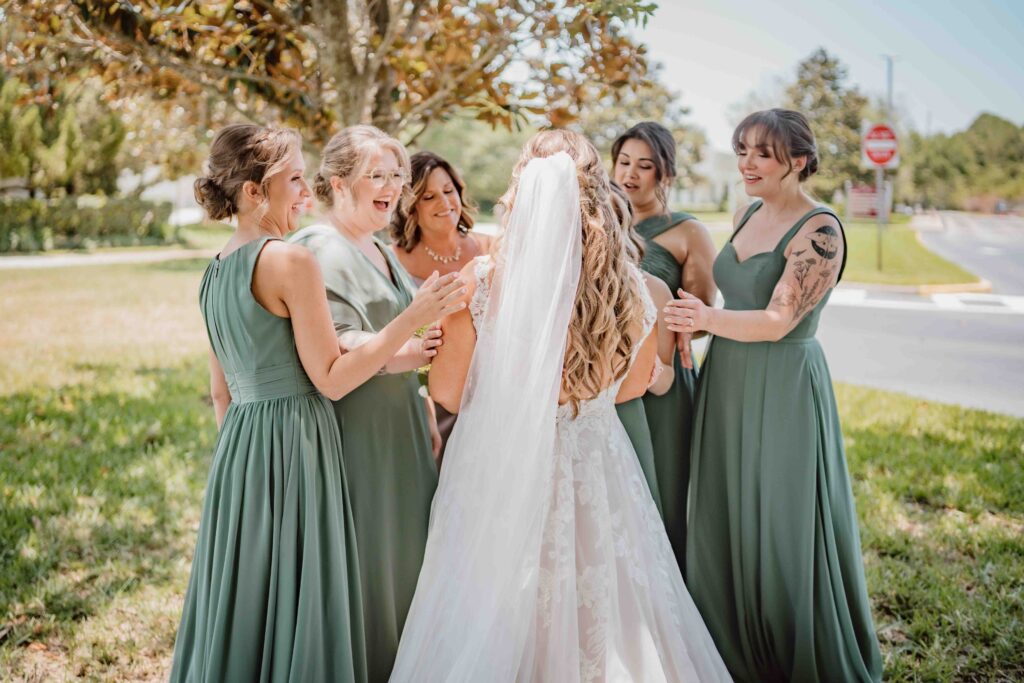 bride talking to her bridesmaids outside 