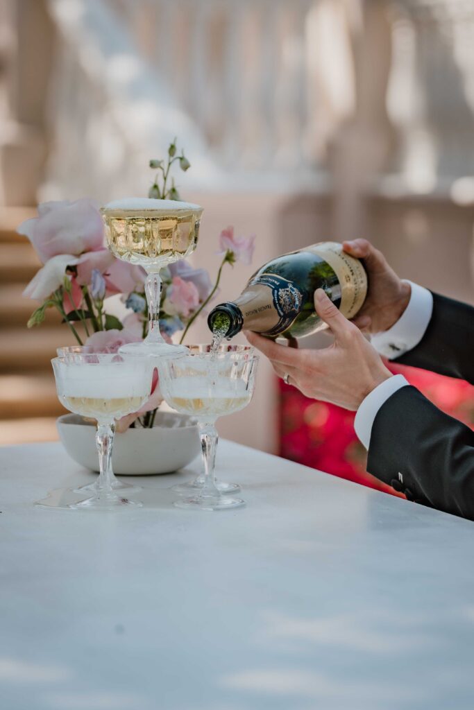 champagne bottle being poured into a champagne tower