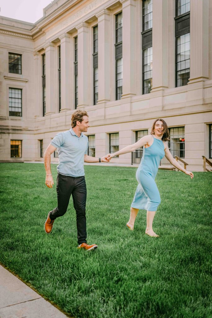 man and woman running in grass in downtown boston