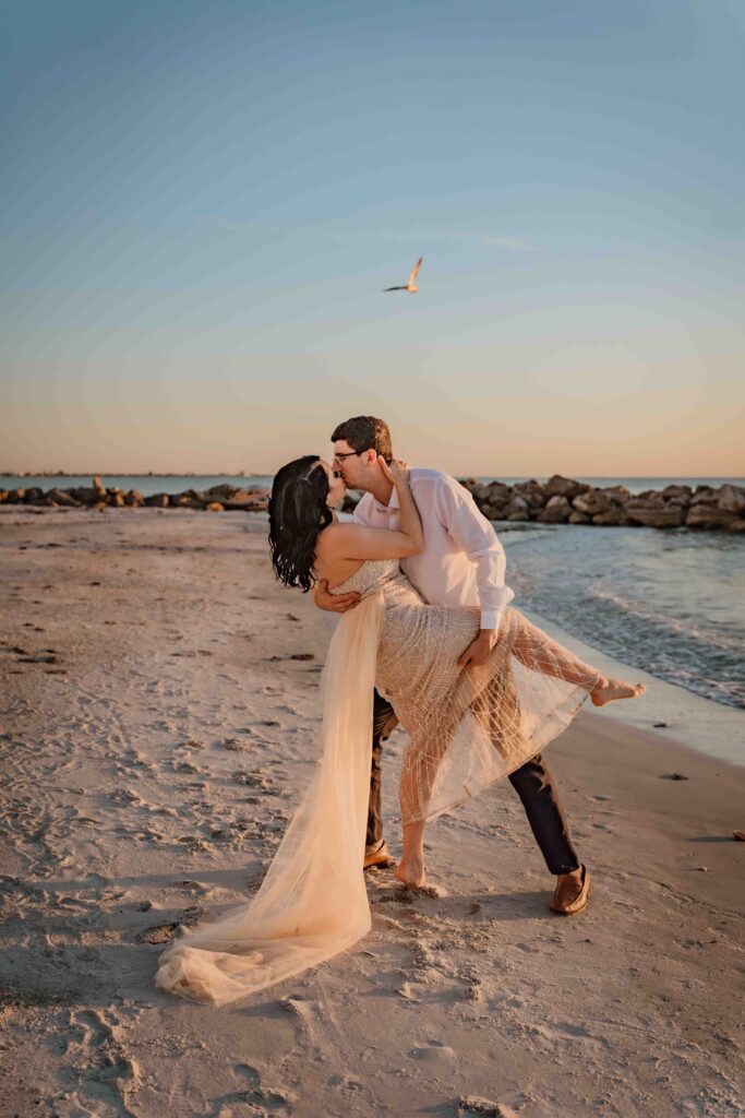 couple kissing at the beach during sunset