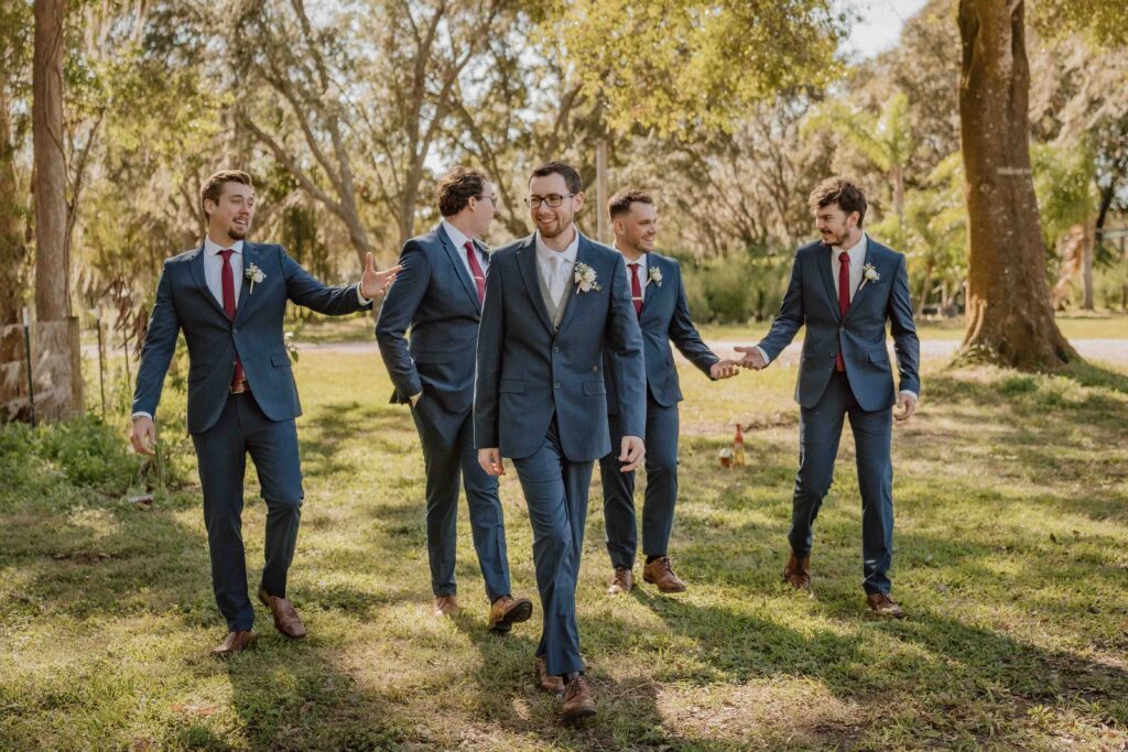 a groom walking with groomsmen behind him to his left and right