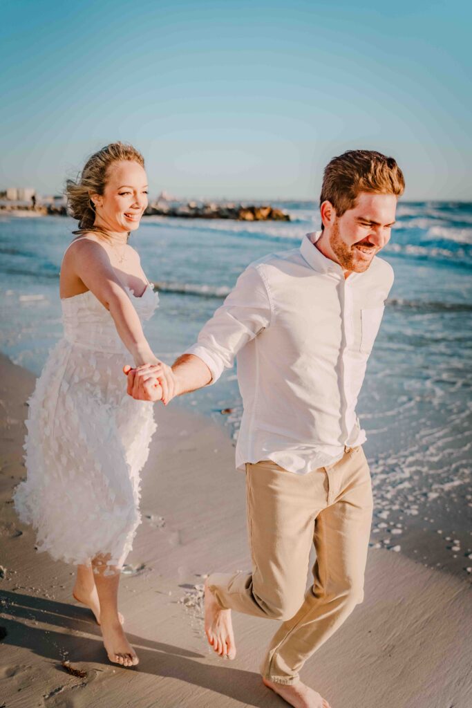woman and man running on the beach at sunset