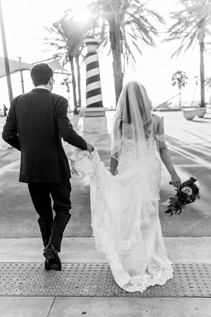 black and white photo of bride and groom walking away
