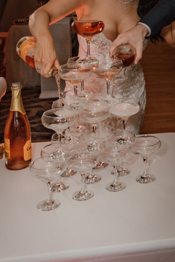 champagne being poured into a champagne tower glasses