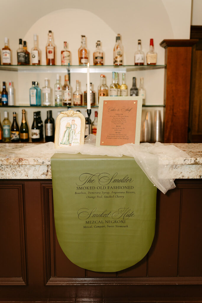 Bar with green leather menu and watercolor painting on top of the bar