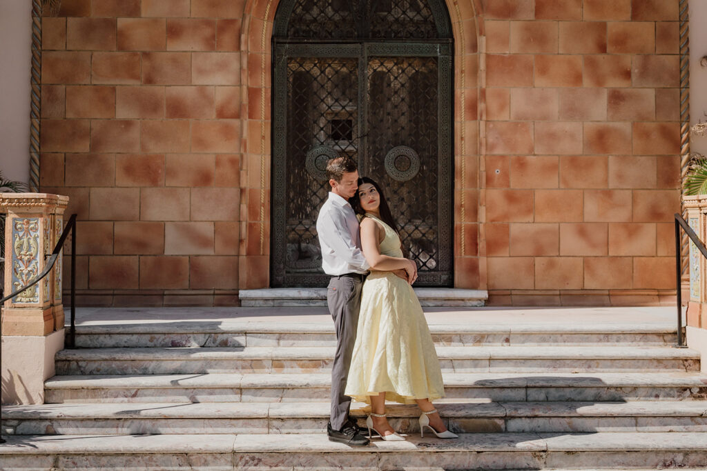 man and woman standing in front of building doors on the steps