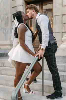 man and woman kissing on stairs in front of courthouse