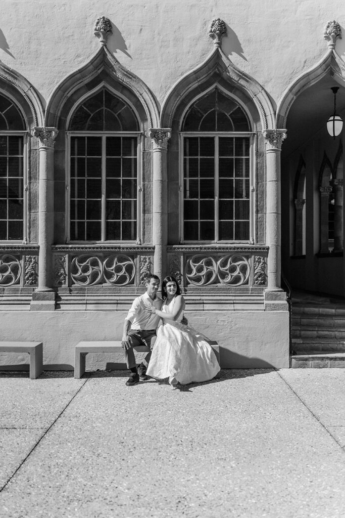 back and white photo of man and woman sitting on a bench in front of the museum