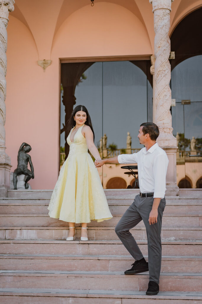 man leading woman down the steps holding hands