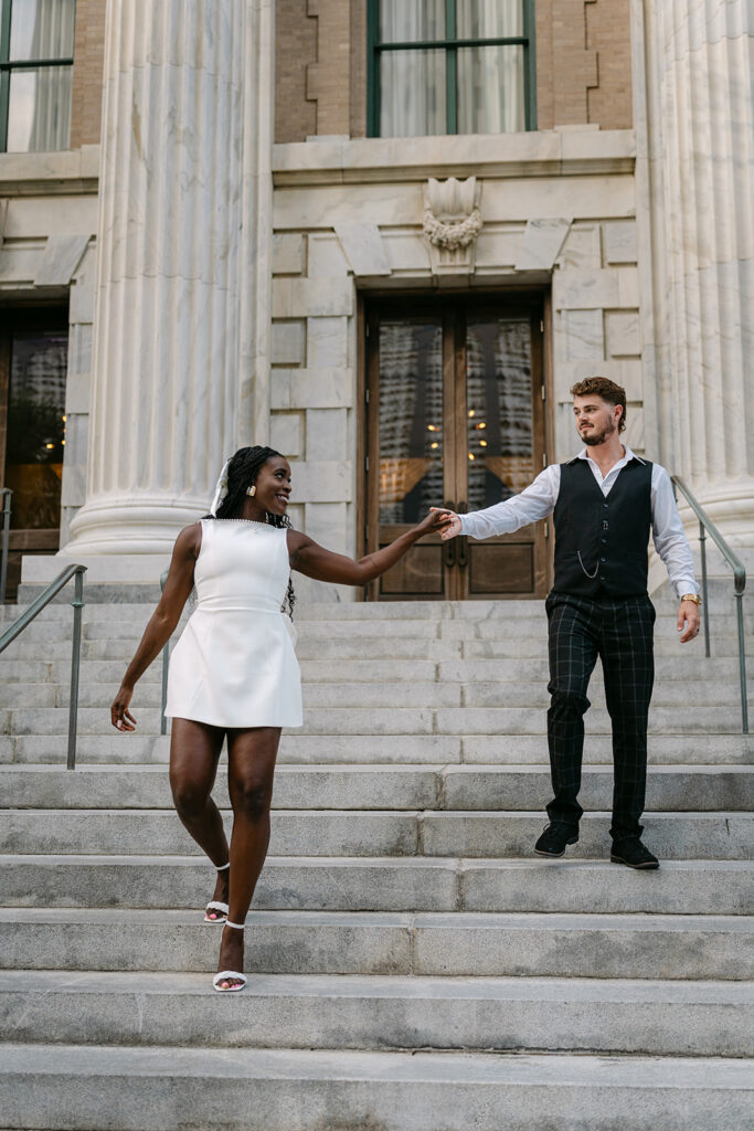 woman leading a man down the steps holding hands