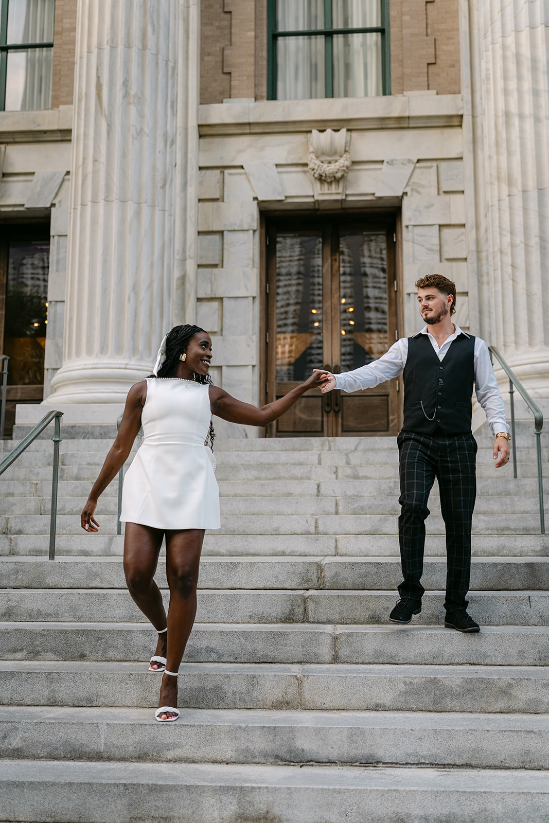 woman leading a man down the steps holding hands