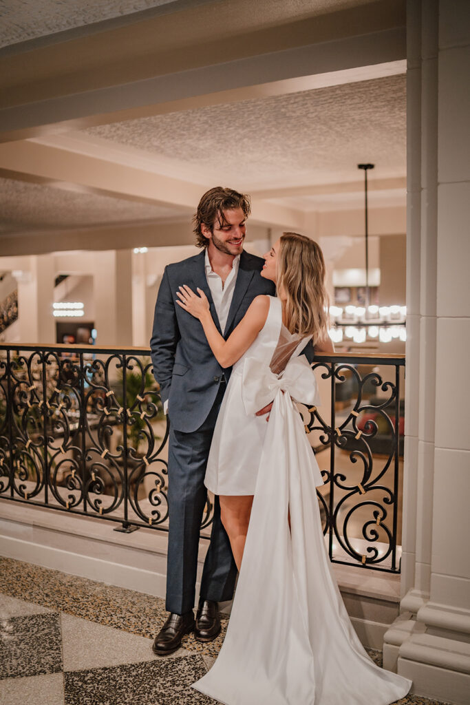 man and woman looking at each other at a hotel standing in front of a railing