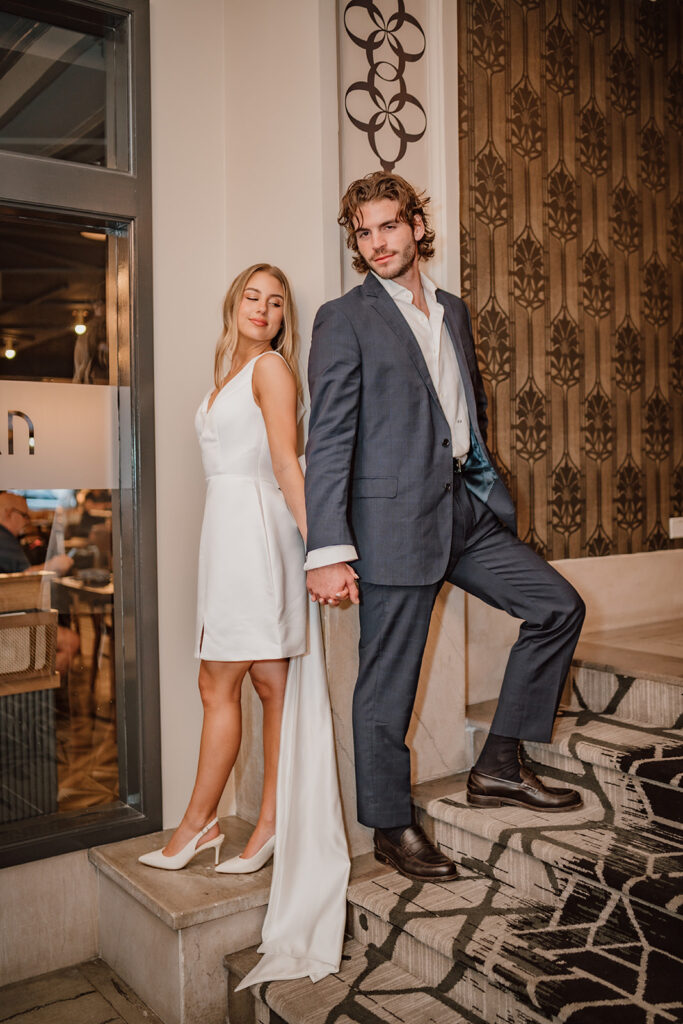 man and woman holding hands leaning against the wall