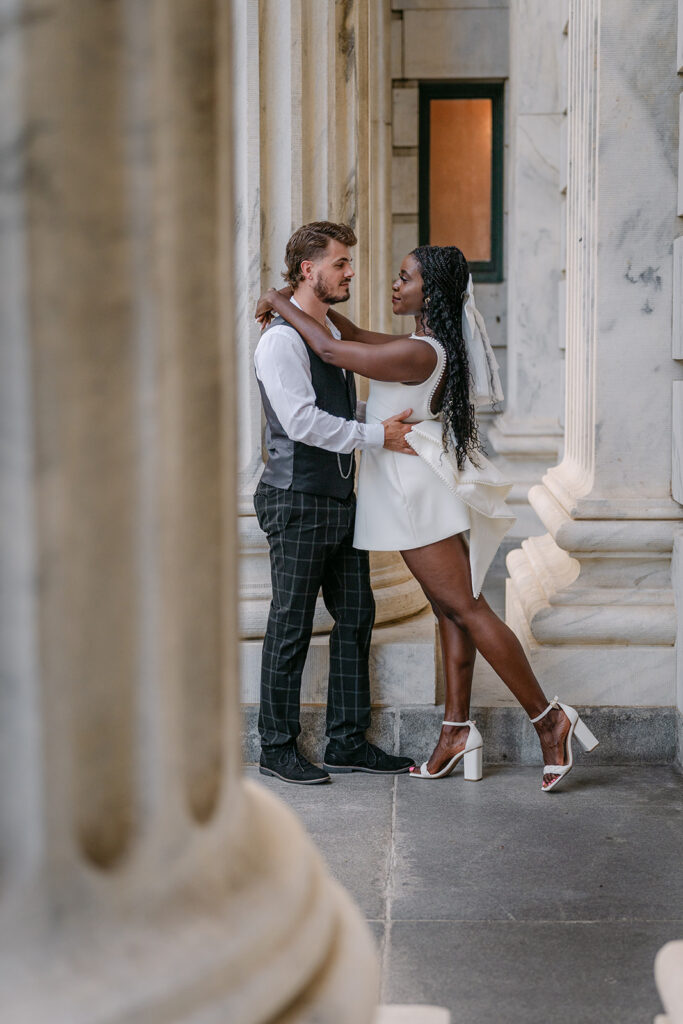 couple facing each other amongst white columns