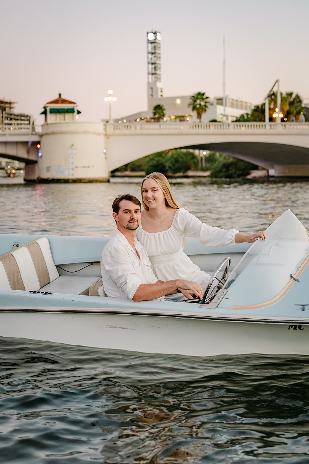 man and woman during an engagment session in downtown tampa on a boat in the water